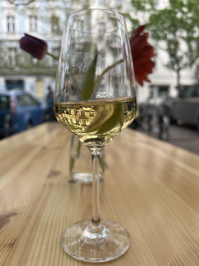 A glass of natural organic Italian wine on the terrace of an Italian pizza restaurant in Berlin. 