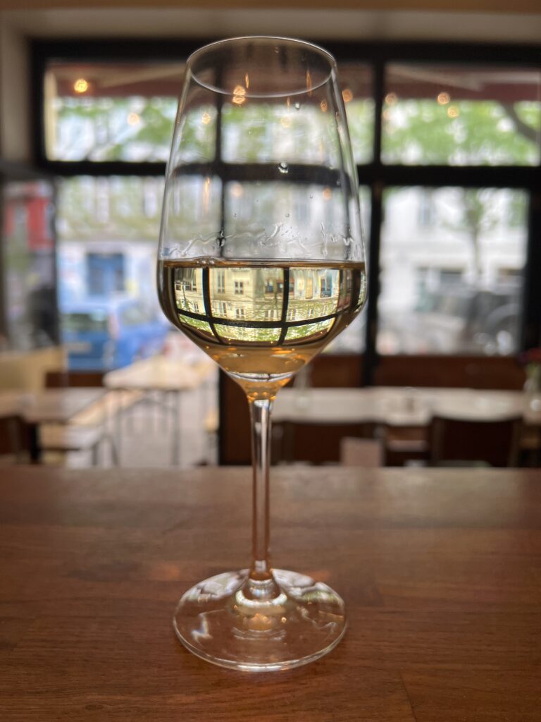 A glass of Italian white wine on the bar of an Italian pizza restaurant in Berlin. 