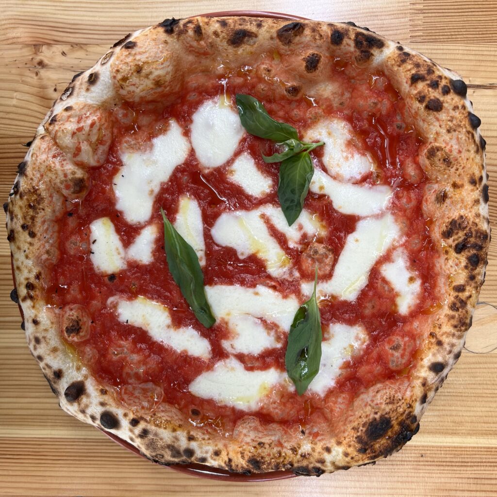 Authentic Neapolitan Margherita pizza with tomato sauce, mozzarella, and fresh basil at a Berlin pizzeria.