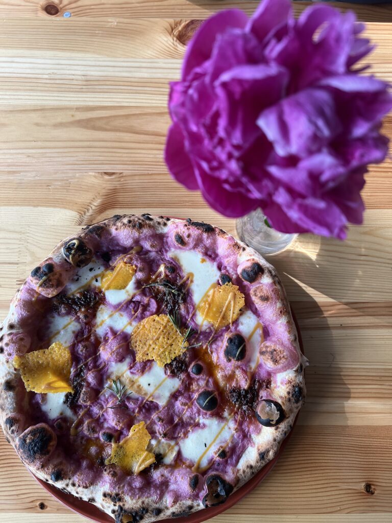 a pizza with a flower in the background